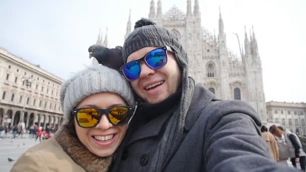 Happy tourists and pigeons taking a self portrait with phone in front of Duomo cathedral,Milan. Winter travel concept — Stock Video