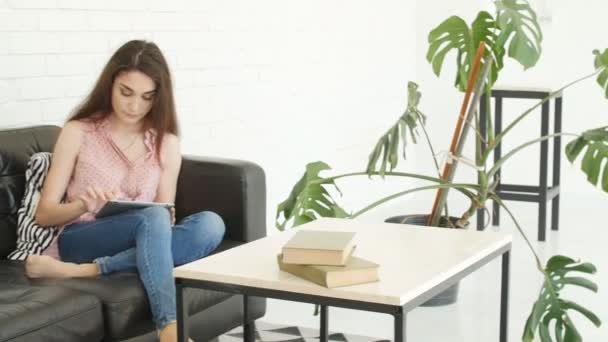 Jeune Femme Assise Sur Canapé Utilisant Une Tablette Dans Appartement — Video