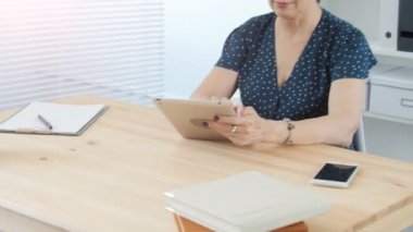 Orta yaşlı bir kadın ofiste tablet kullanma