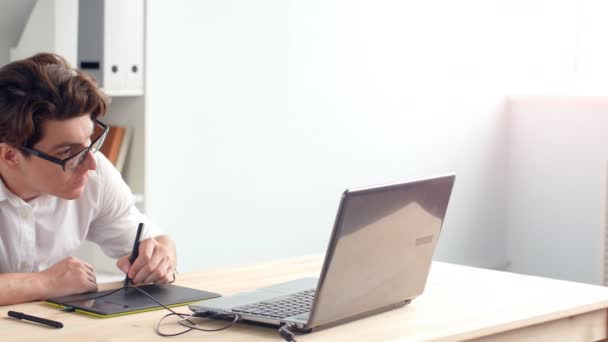 Designer maschile casuale utilizzando tablet grafica in un ufficio luminoso — Video Stock
