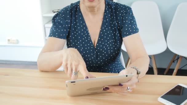 Frau mittleren Alters im Büro arbeitet an digitalem Tablet — Stockvideo