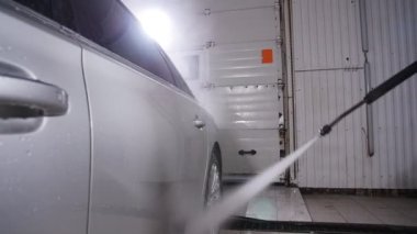 Adam araba yüksek basınçlı su ile yıkar