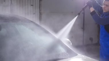 Adam araba yüksek basınçlı su ile yıkar