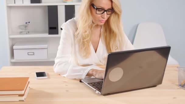 Mujer joven usando el ordenador portátil en la oficina moderna — Vídeos de Stock