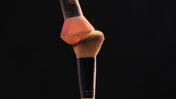 Makijaż i koncepcja piękna. Szczotka z różowym wybuchem proszku na czarnym tle — Wideo stockowe