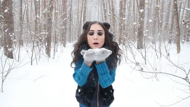 Concepto de entretenimiento invernal. Mujer joven en el parque de invierno con nieve en las manos — Vídeos de Stock