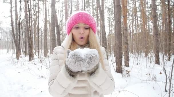 Concept of winter entertainment. Young woman in winter park with snow in hands — Stock Video