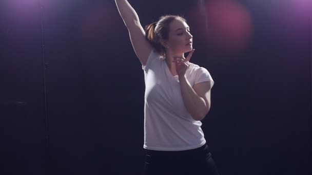 Έννοια του χορού. Νεαρή γυναίκα που χορεύει, με φως στο φόντο — Αρχείο Βίντεο
