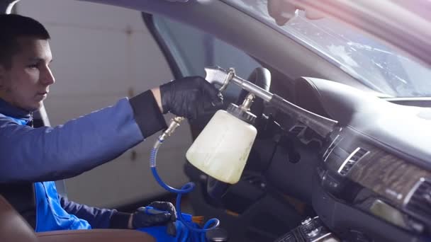 Concepto de limpieza interior del coche. Un hombre limpia un coche con productos químicos — Vídeo de stock