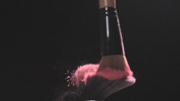 Duas escovas de maquilhagem com pó rosa sobre um fundo preto — Vídeo de Stock
