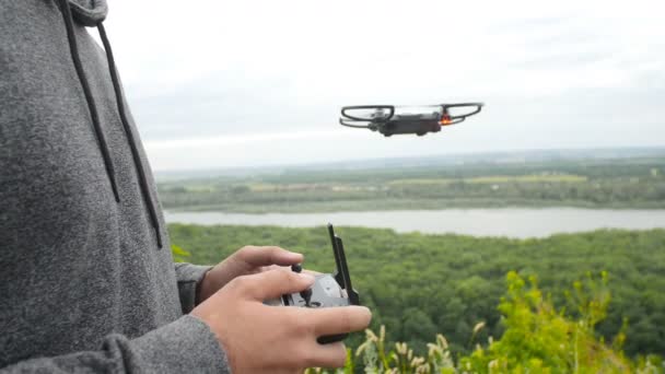 Hombre controlando un dron cuadrohelicóptero — Vídeo de stock