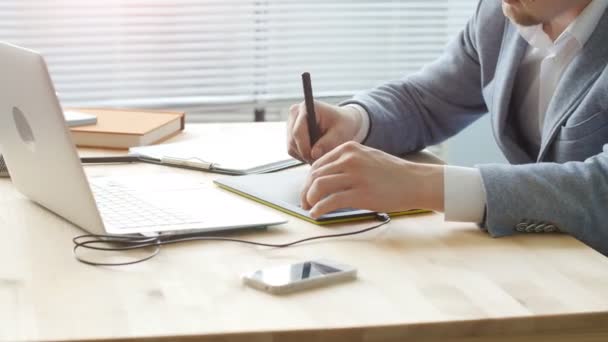 Office work concept. A young male designer works on a graphic tablet — Stock Video