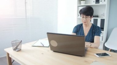Ofiste dizüstü bilgisayarda çalışma çekici olgun işkadını