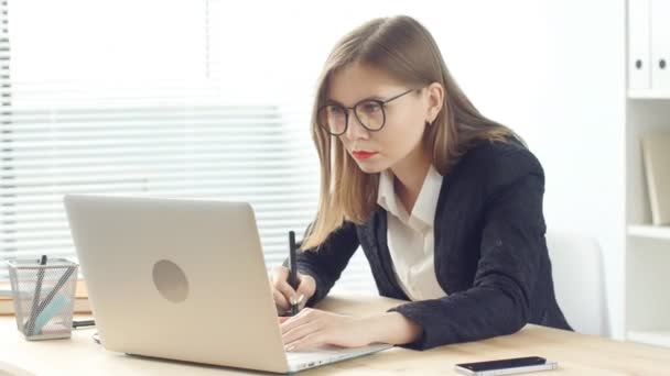 Jovem designer gráfico mulher trabalhando no laptop usando tablet no escritório moderno — Vídeo de Stock