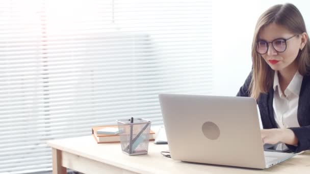 Jeune femme graphiste travaillant sur ordinateur portable en utilisant une tablette au bureau moderne — Video