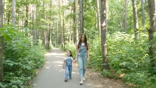 Conceito familiar. Jovem mãe e criança filha de mãos dadas e andar — Vídeo de Stock