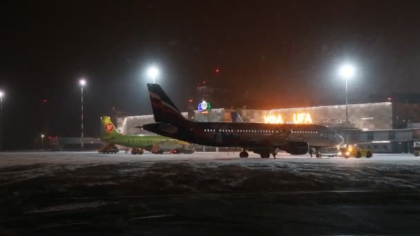 UFA, Rusko - 1 dubna 2018: Ufa mezinárodní letiště. Pohled do noci zimní letiště a letadla letecké společnosti Aeroflot. — Stock video