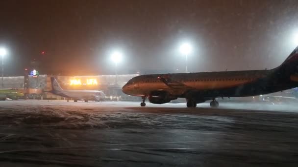 UFA, Rusko - 1 dubna 2018: Ufa mezinárodní letiště. Pohled do noci zimní letiště a letadla letecké společnosti Aeroflot. — Stock video