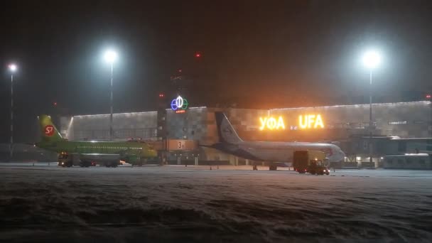 UFA, RUSIA - 1 DE ABRIL DE 2018: Aeropuerto Internacional de Ufa. Vista al aeródromo nocturno de invierno y aviones de Aeroflot Airlines . — Vídeos de Stock