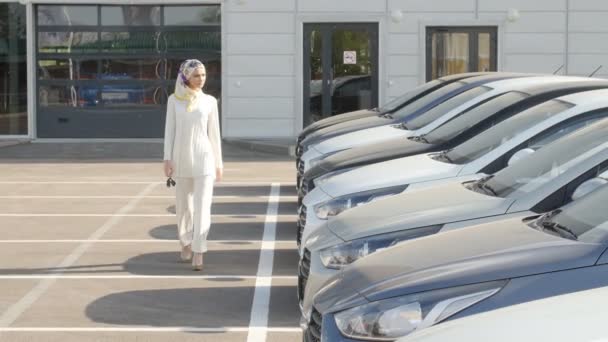 Kauf oder Vermietung eines Autos Konzept. junge muslimische Frau entscheidet sich für ein Auto zum Kauf oder Mieten — Stockvideo