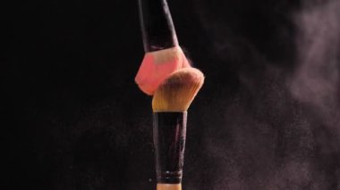 Kozmetik ve güzellik kavramı. Siyah arka plan üzerine pastel pembe kozmetik tozu ile kozmetik fırça
