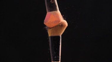 Kozmetik ve güzellik kavramı. Siyah arka plan üzerine pastel pembe kozmetik tozu ile kozmetik fırça