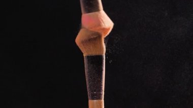 Kozmetik ve güzellik kavramı. Siyah arka plan üzerine pastel pembe kozmetik tozu ile kozmetik fırça