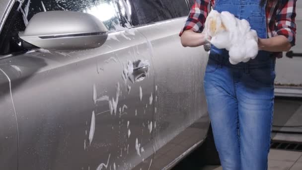 Jonge vrouw wassen van een auto met een spons — Stockvideo