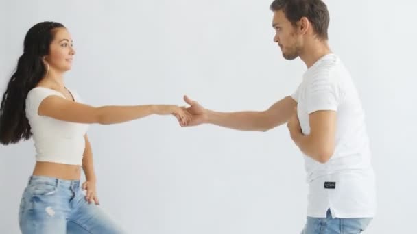 Concetto di danza sociale. Giovane coppia romantica ballare su sfondo bianco — Video Stock
