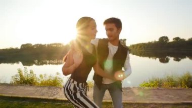 Aşk ve ilişkiler kavramı. Genç çift günbatımında dans