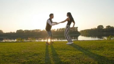 Aşk ve ilişkiler kavramı. Genç çift günbatımında dans