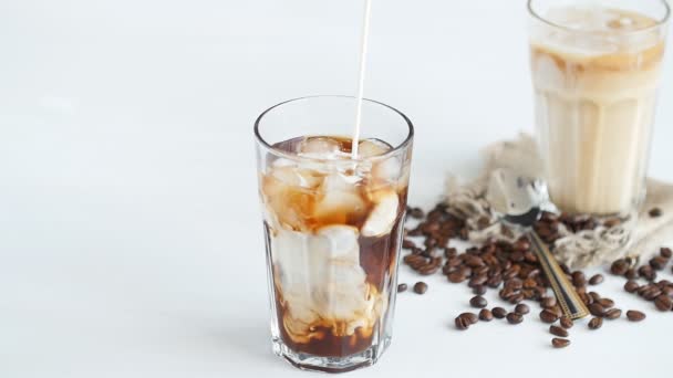 Concept of coffee and cocktails. Cream poured into coffee with ice — Stock Video