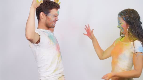 Mladý šťastný pár baví hrát si s barevnými holi prášek — Stock video