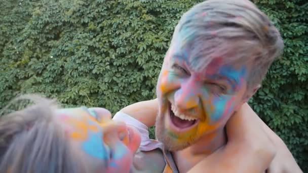 Jonge gelukkige paar plezier spelen met kleurrijke holi poeder — Stockvideo