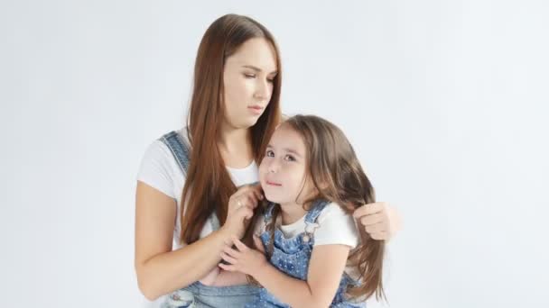 Conceito familiar. Uma jovem mãe está penteando uma pequena filha — Vídeo de Stock