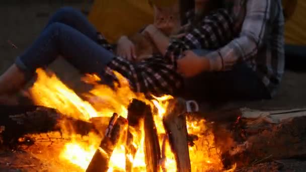 Conceito de amizade, amor e relações. Jovem feliz casal sentado com fogueira na praia à noite — Vídeo de Stock