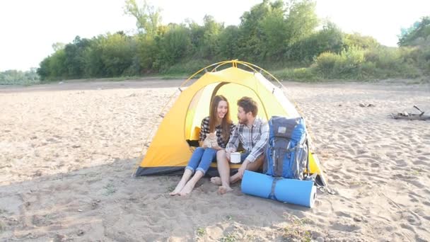 Concept of tourism and travel. Young happy couple sitting in tent watching the view — Stock Video