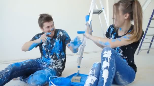 Jeune couple heureux s'amuser pendant la rénovation et la peinture de leur appartement — Video