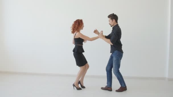 Beleza jovem casal dançando dança social em uma sala branca. Kizomba ou bachata ou semba ou taraxia — Vídeo de Stock