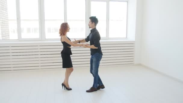 Szépség a fiatal pár táncoló szociális tánc, egy fehér szobában. Kizomba vagy bachata vagy semba vagy taraxia — Stock videók