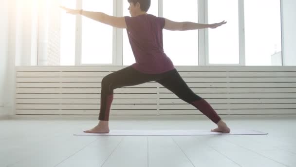 Konsep harmoni, olahraga dan kesehatan. Wanita paruh baya melakukan yoga di interior putih — Stok Video
