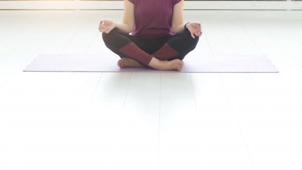 Conceito de harmonia, esporte e saúde. Mulher de meia-idade fazendo ioga em um interior branco — Vídeo de Stock
