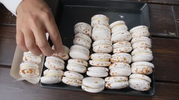 Concepto de pequeña empresa y confitería. Las manos de los pasteleros ponen macarrones en una caja — Vídeos de Stock