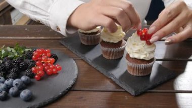 Küçük işletme ve şekerlemeler kavramı. Bayan baker çilek ile lezzetli kek dekorasyon