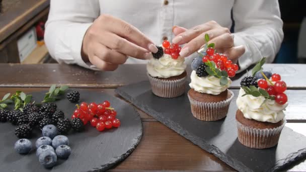 Conceito de pequenas empresas e confeitaria. Fêmea padeiro decoração saboroso cupcake — Vídeo de Stock