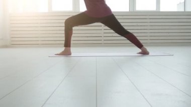 Orta yaşlı bir kadın beyaz iç evde yoga yaparken
