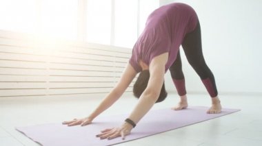 Orta yaşlı bir kadın beyaz iç evde yoga yaparken