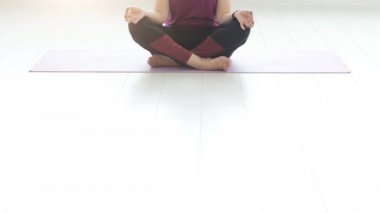 Orta yaşlı bir kadın beyaz iç evde yoga yaparken