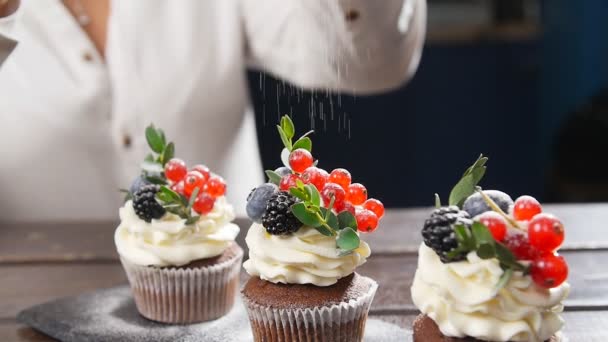 Baker διακόσμησης νόστιμο cupcake. Ζάχαρη άχνη σκορπιστεί στο κέικ — Αρχείο Βίντεο