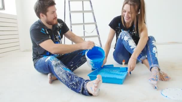 Reparación, construcción y nuevo concepto de hogar. Feliz joven pareja con gato pintura plana — Vídeo de stock